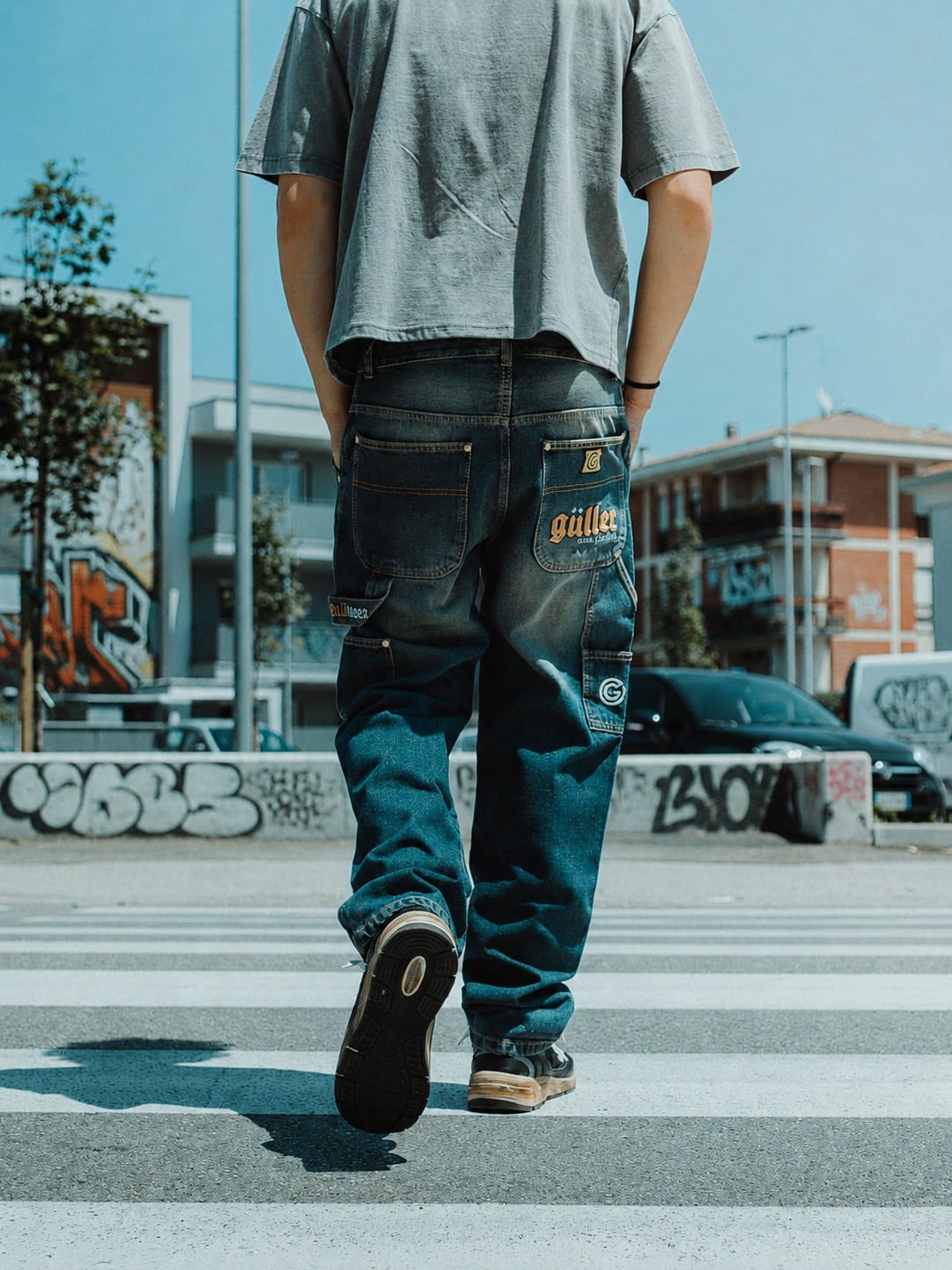 Jeans baggy Güller di spalle sulle strisce pedonali