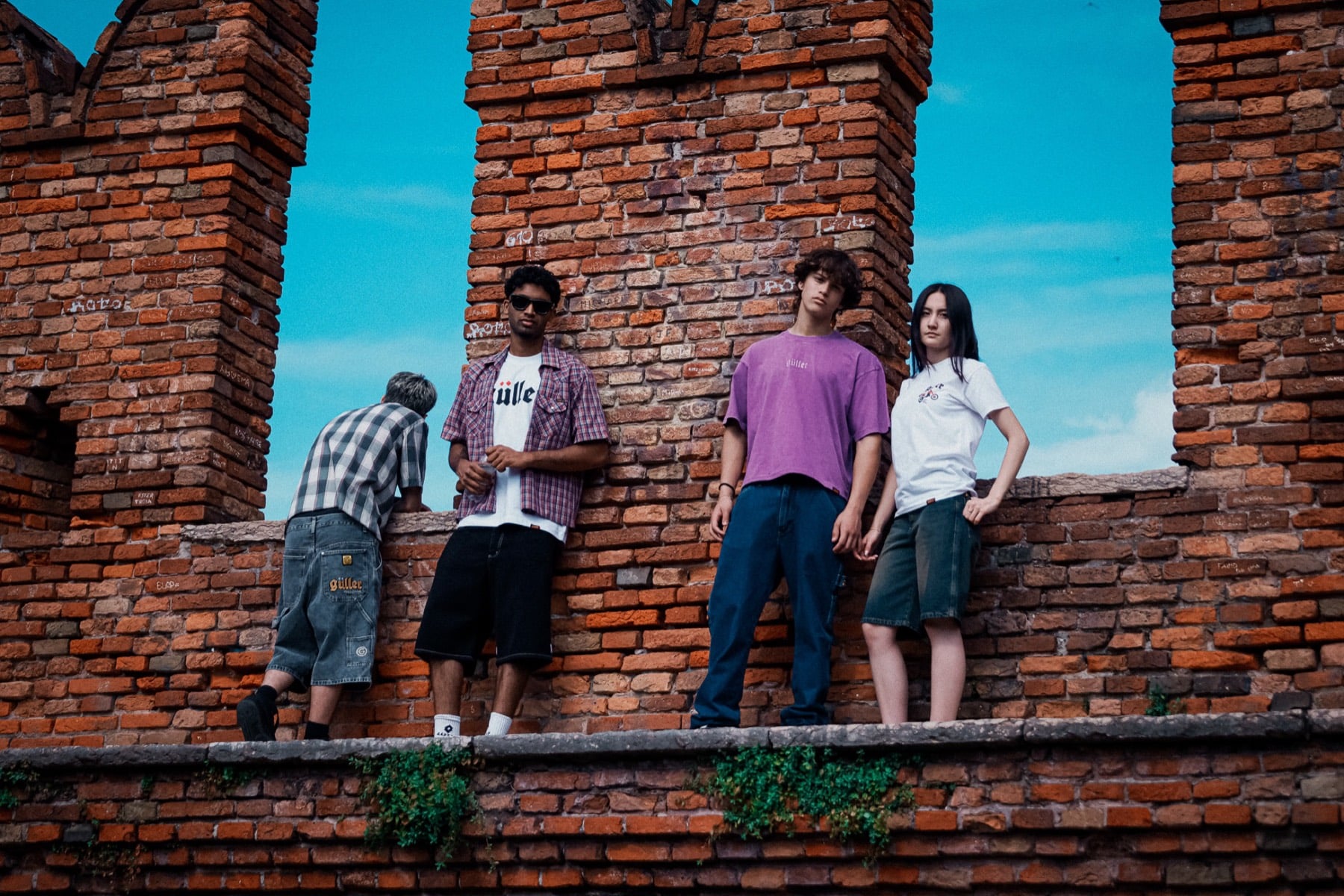 Quattro ragazzi con capi Güller sulle mura di Castelvecchio, a Verona